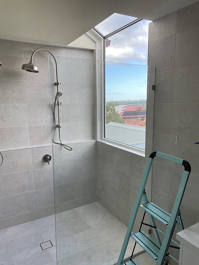 cream coloured shaped and butt joint fixed window in the bathroom