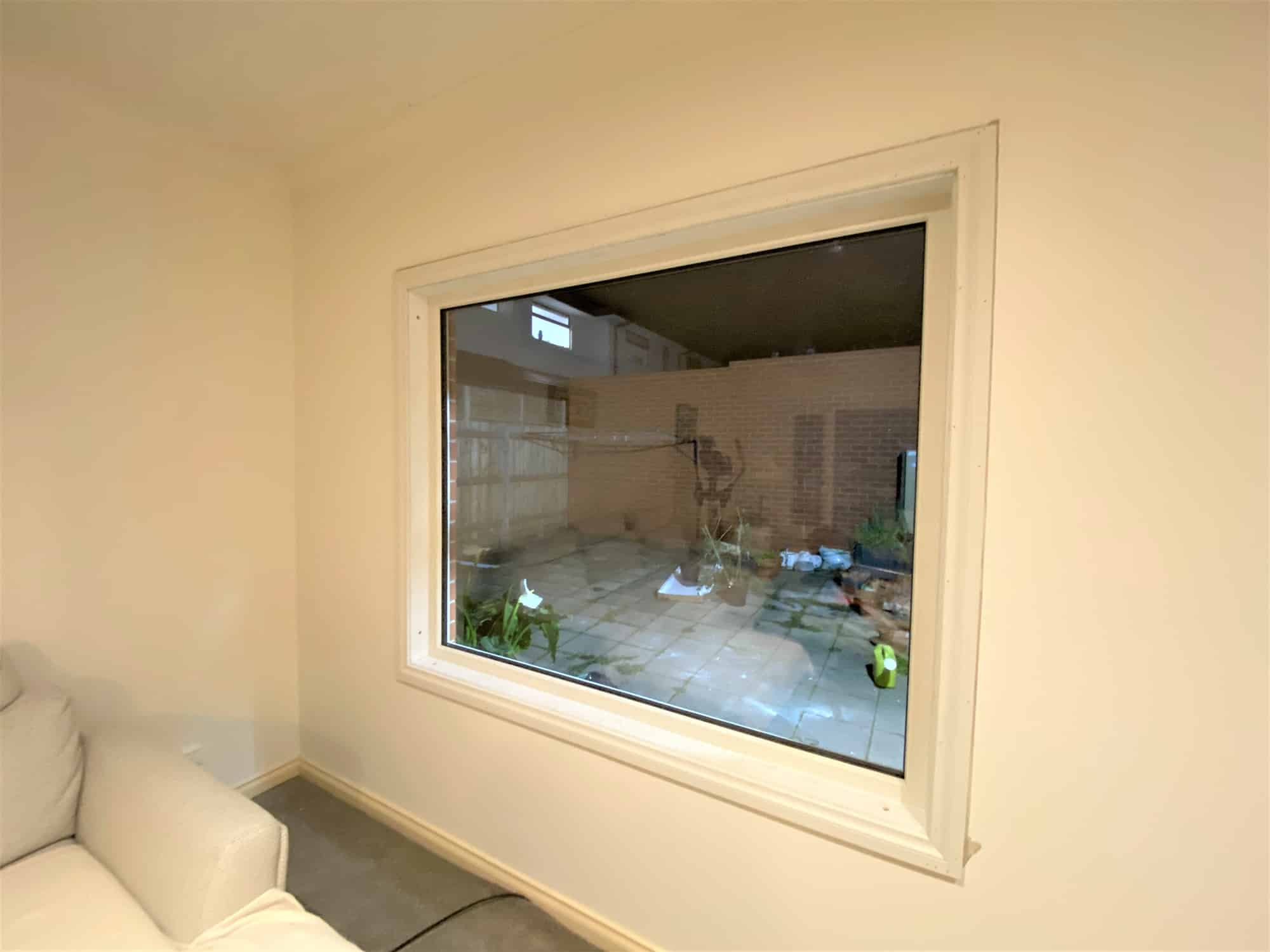 Cream-coloured fixed window with a garden view in the living room